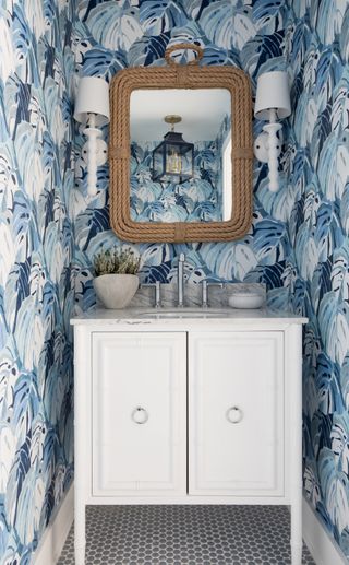 powder room with white vanity and blue wallpaper