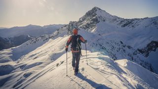 A climber crossing a snowy peak