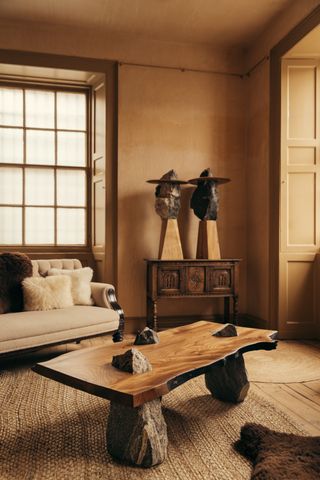 a warm colored living room with a coffee table made from wood and rocks