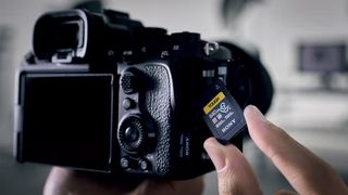 A Sony Tough CFexpress Type A memory card being inserted into a camera