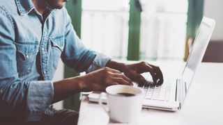 Man using laptop with a cup of coffee