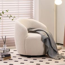 Amazon boucle chair in living room with blanket on it