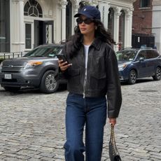 stores like anthropologie shown in a photo of a woman wearing a leather jacket over a white t-shirt and jeans 