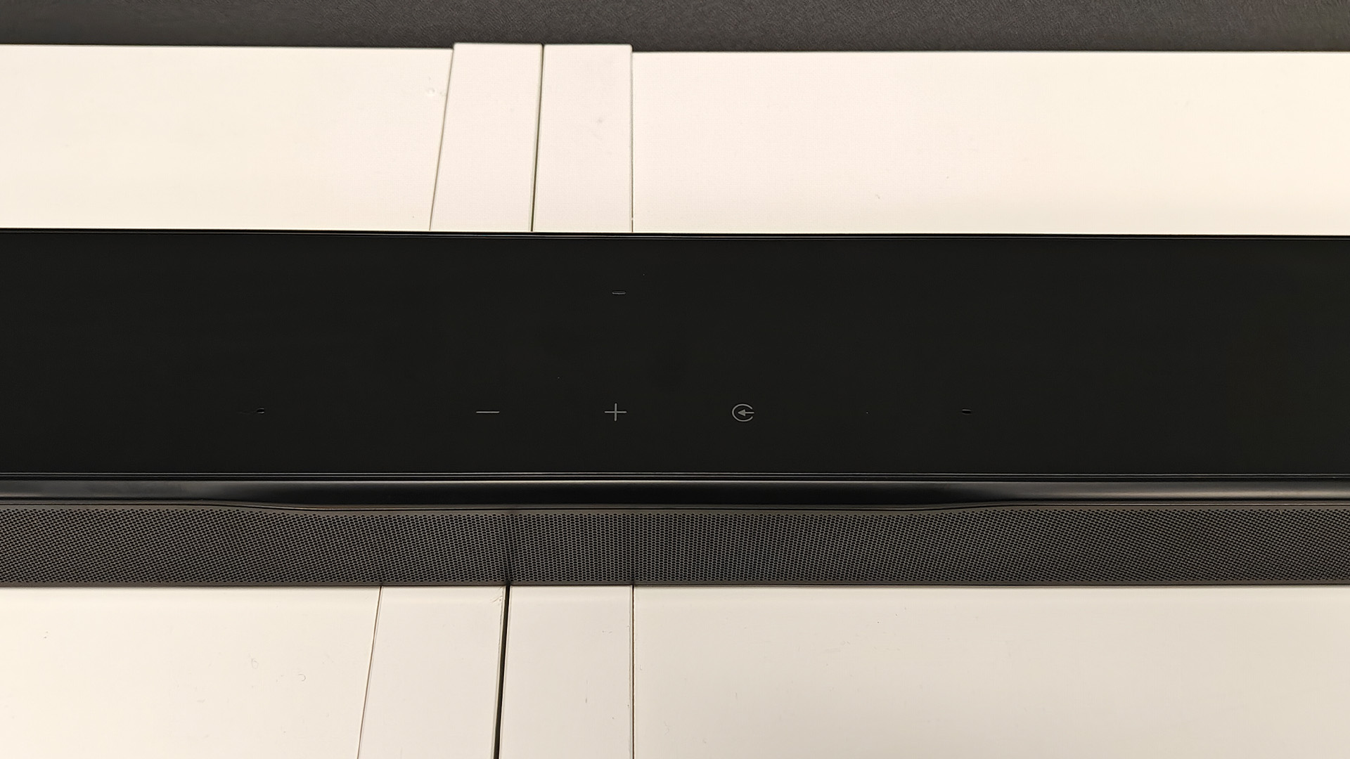 JBL Bar 300MK2 Dolby Atmos soundbar on white wooden shelves close up on controls