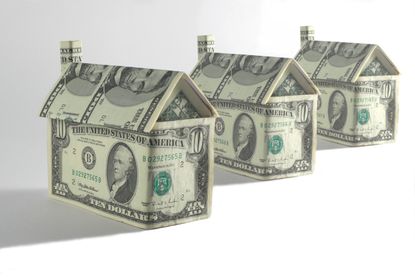 Three houses made out of $5 and $10 bills