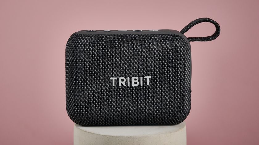 Tribit PocketGo on stand, against pink background