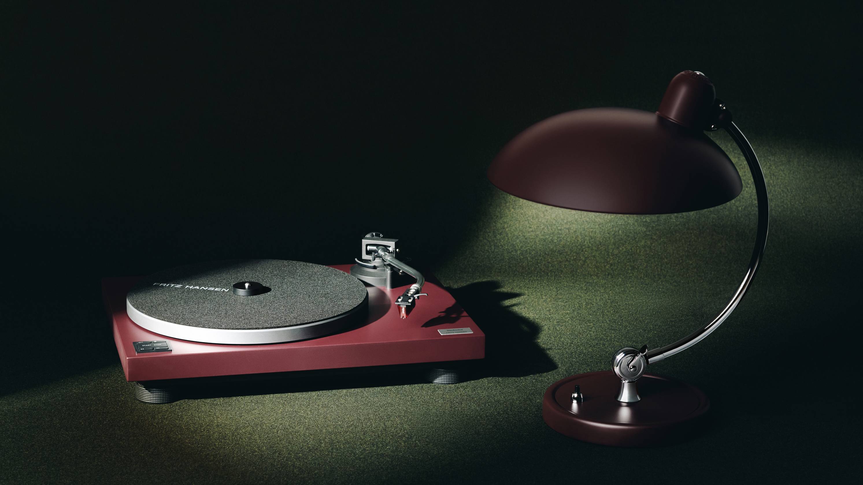 The red Technics SL-40CBT next to a red Kaiser idell lamp.