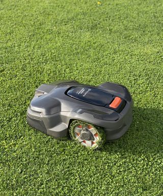 Husqvarna Automower 415x on a lawn with mowed grass clippings on its wheels