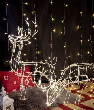 net fairy lights on the wall and light up reindeer