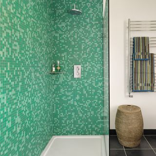 bathroom with mosaic tiles on wall bathtub and black flooring
