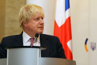 The UK prime minister Boris Johnson standing by a lecturn