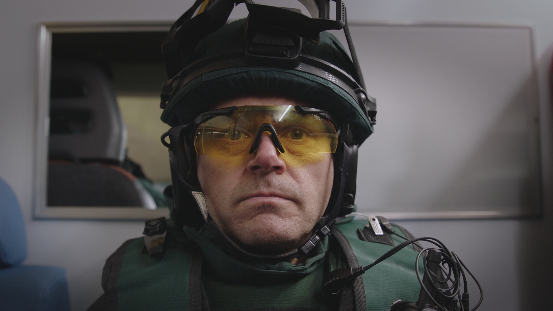 EMBARGO 16/09 Iain Dean is protective combat gear with yellow eye protectors and helmet looking very serious in the back of a van.