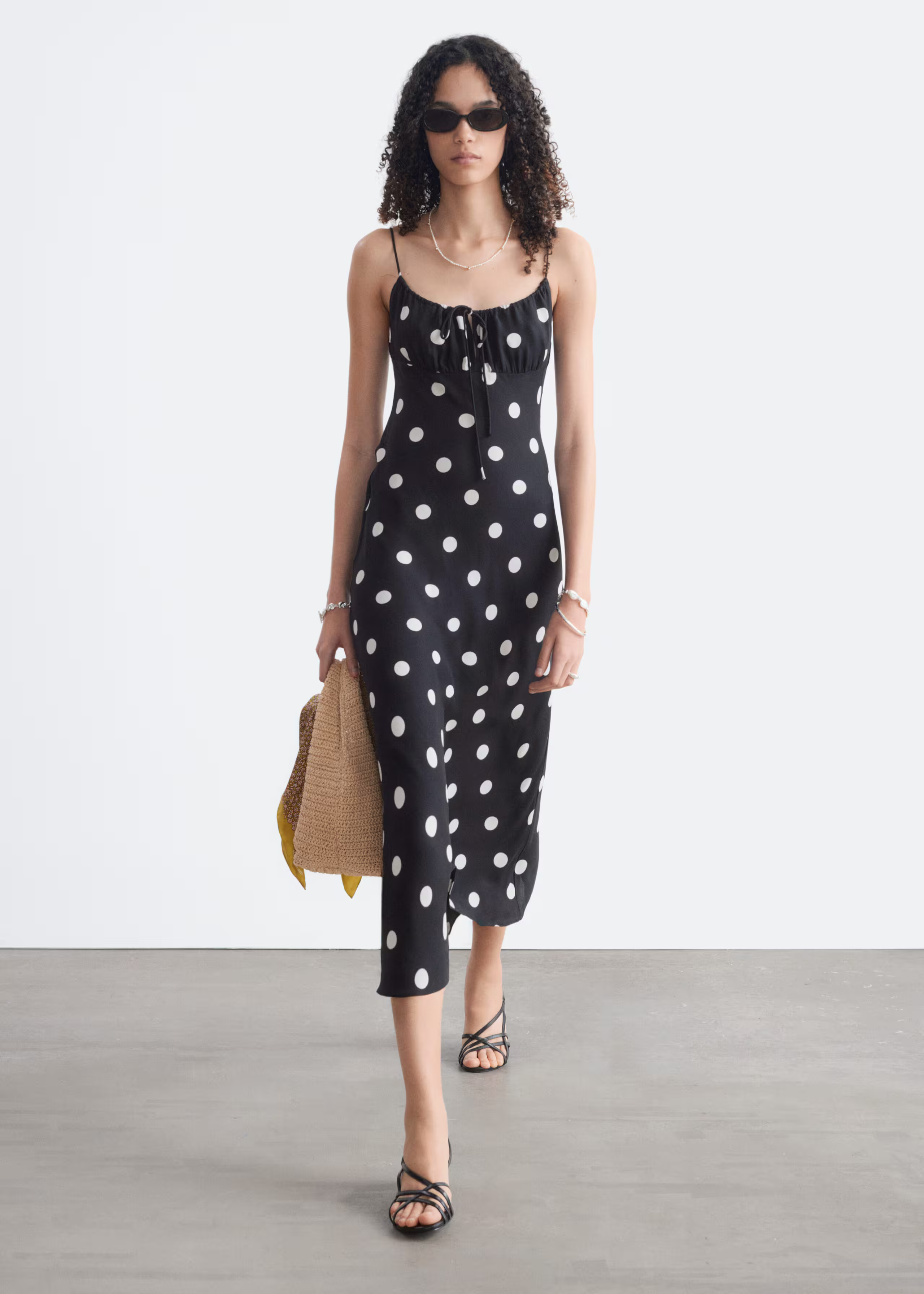 A model wearsa black &amp;amp; Other Stories polkadot dress.