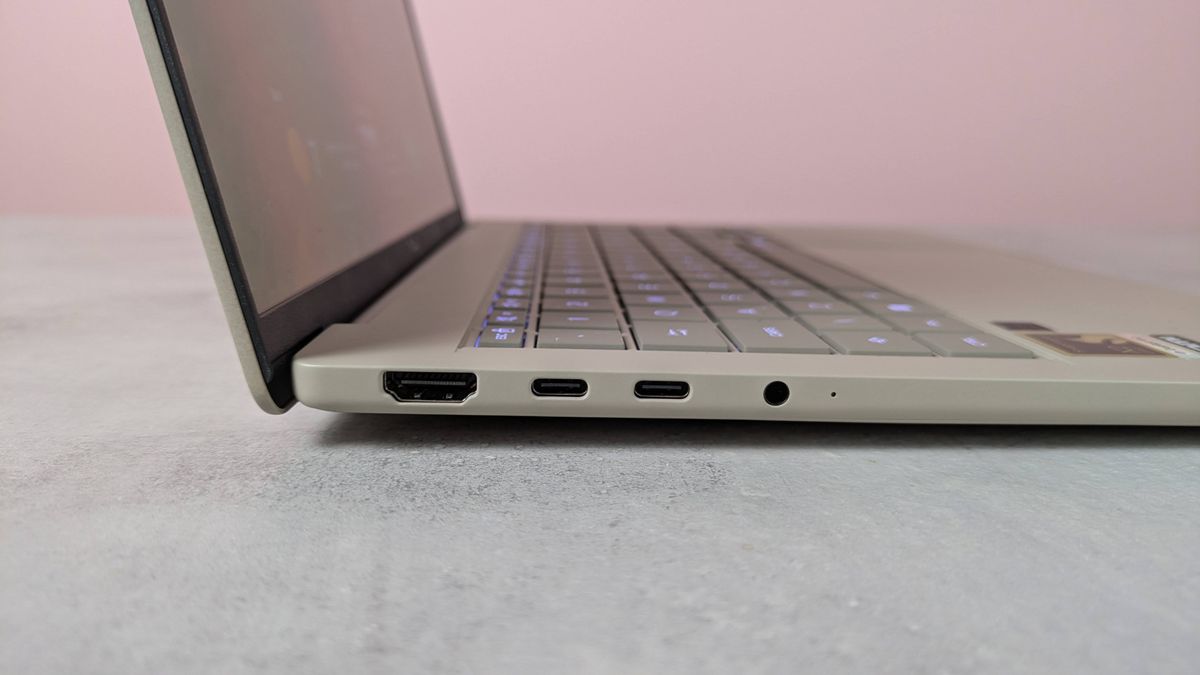 Close-up of left-hand side ports on Asus Zenbook A14, on a desk with pink wall in background