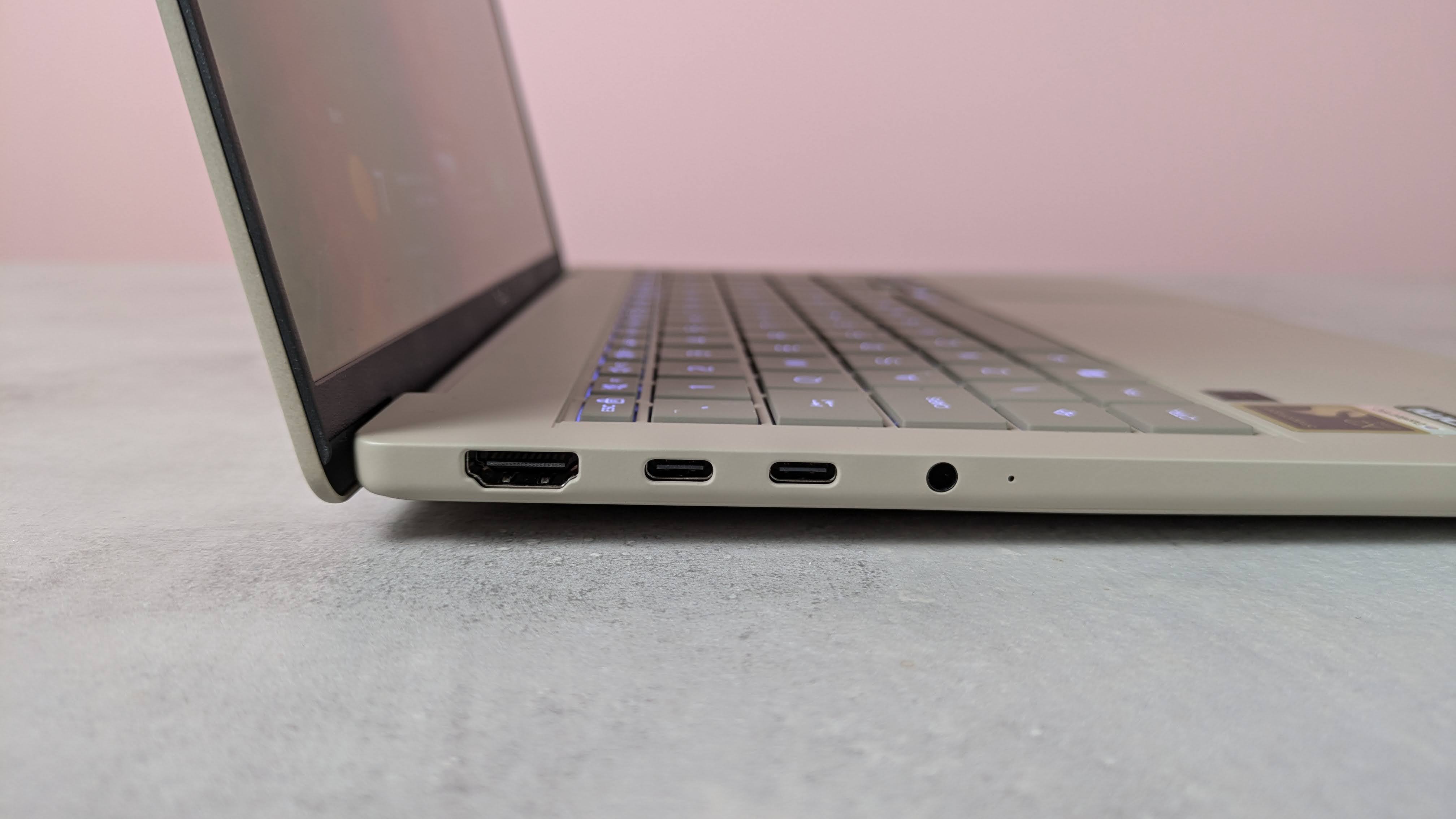 Close-up of left-hand side ports on Asus Zenbook A14, on a desk with pink wall in background