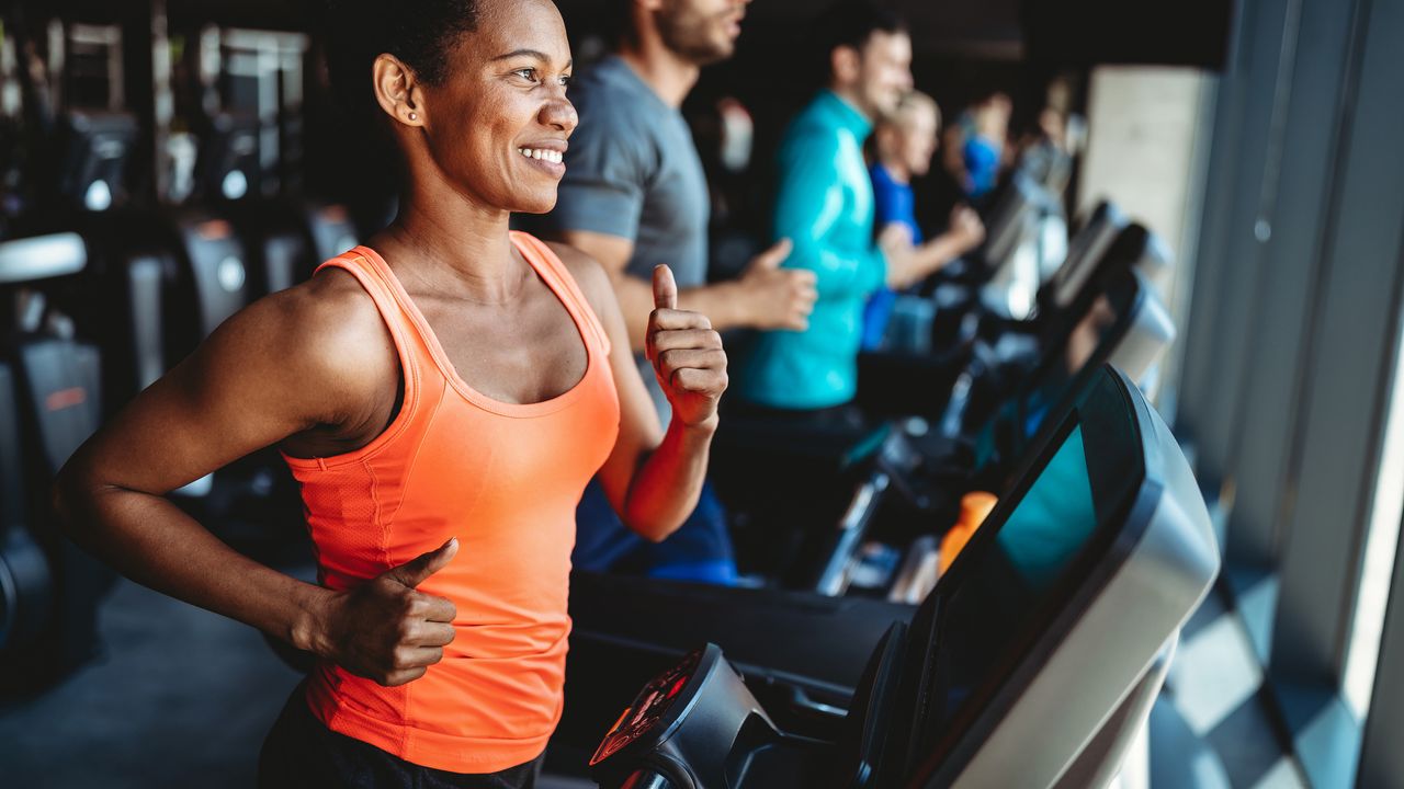 Happy beautiful woman smiling and working out in gym