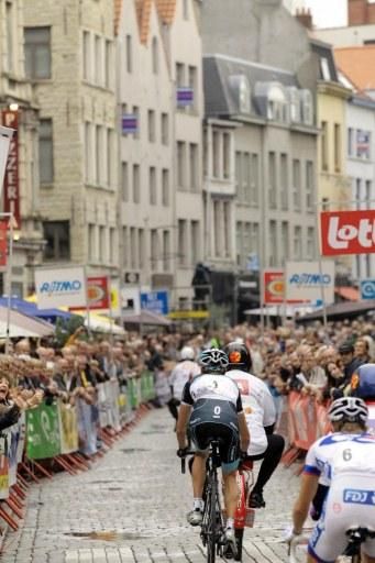Andy Schleck and the other derny race competitors speed through historic Antwerp