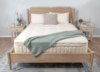 A Naturepedic Concerto mattress on a wooden bed frame