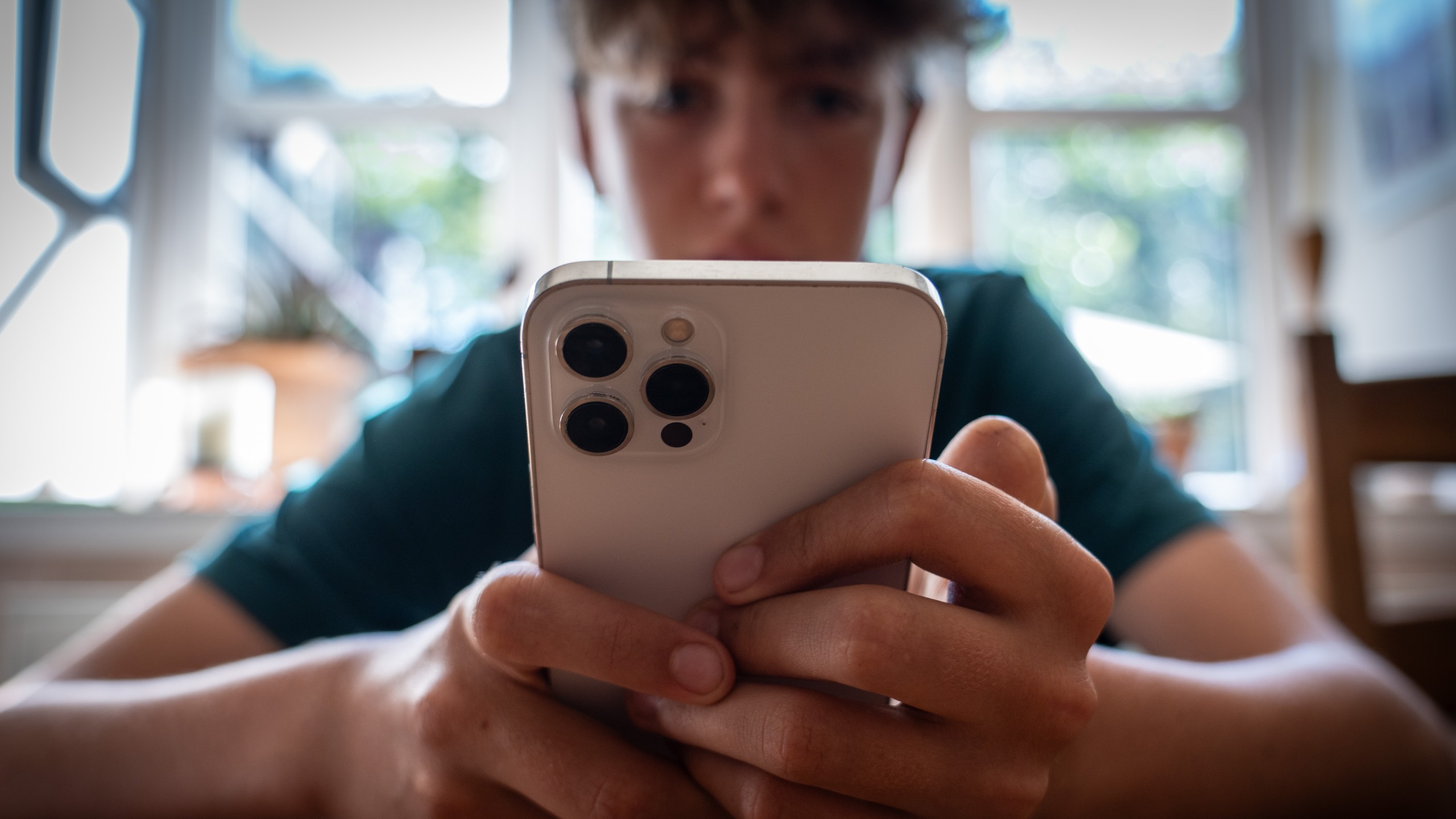 A child holding an iPhone in their hands