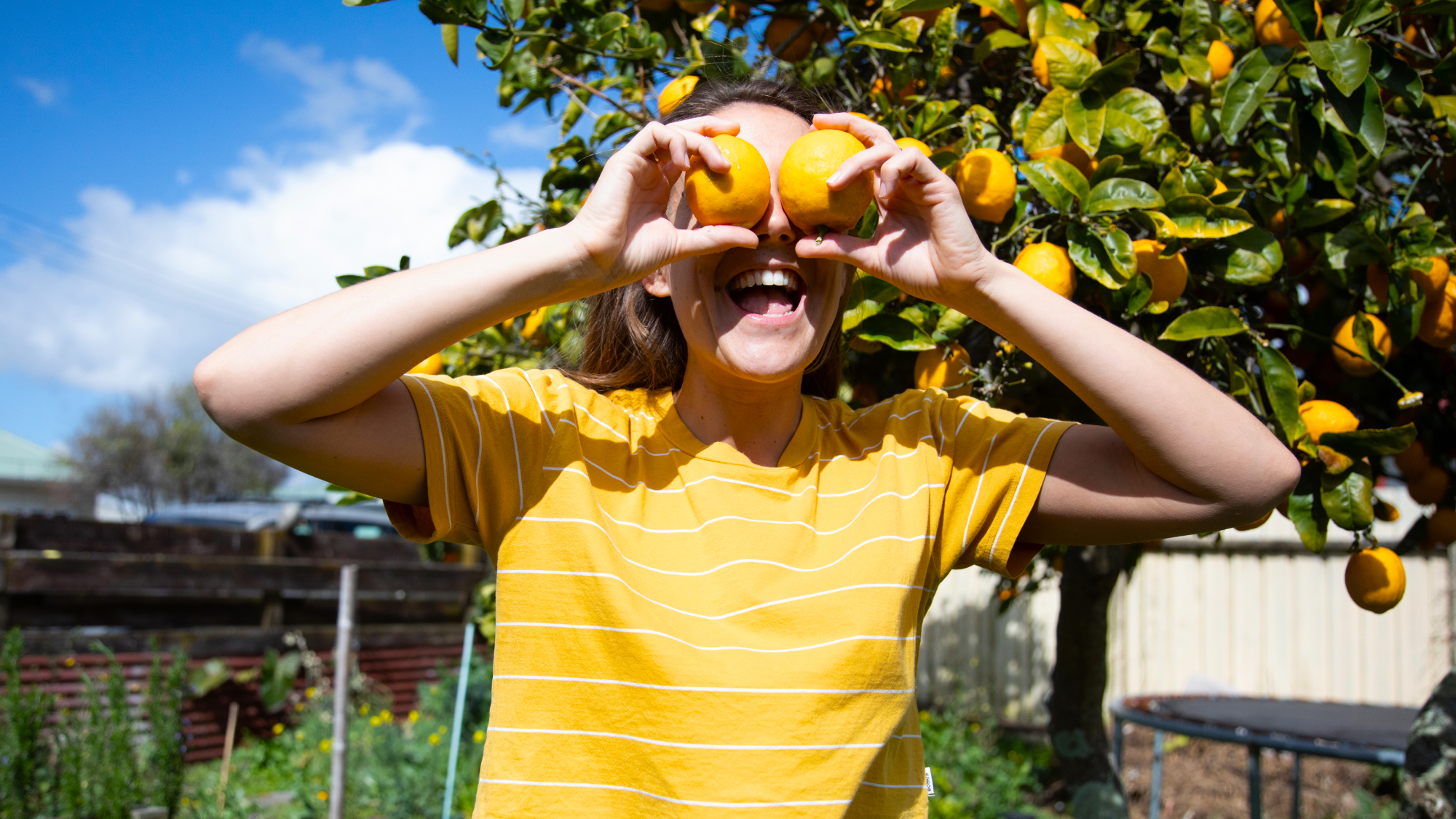 woman holding lemons up to her eyes