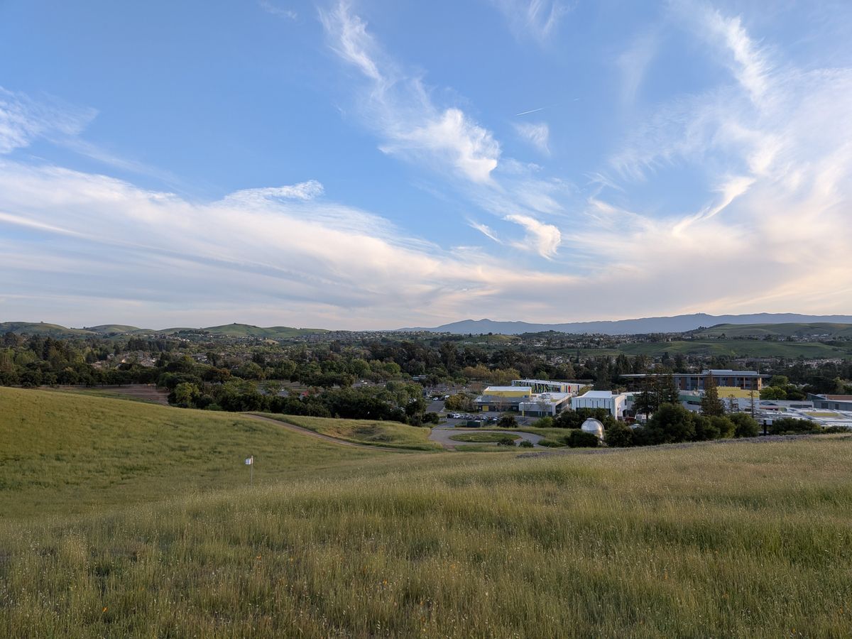 A Google Pixel 9a camera sample showing a landscape shot from a hill down over a college.