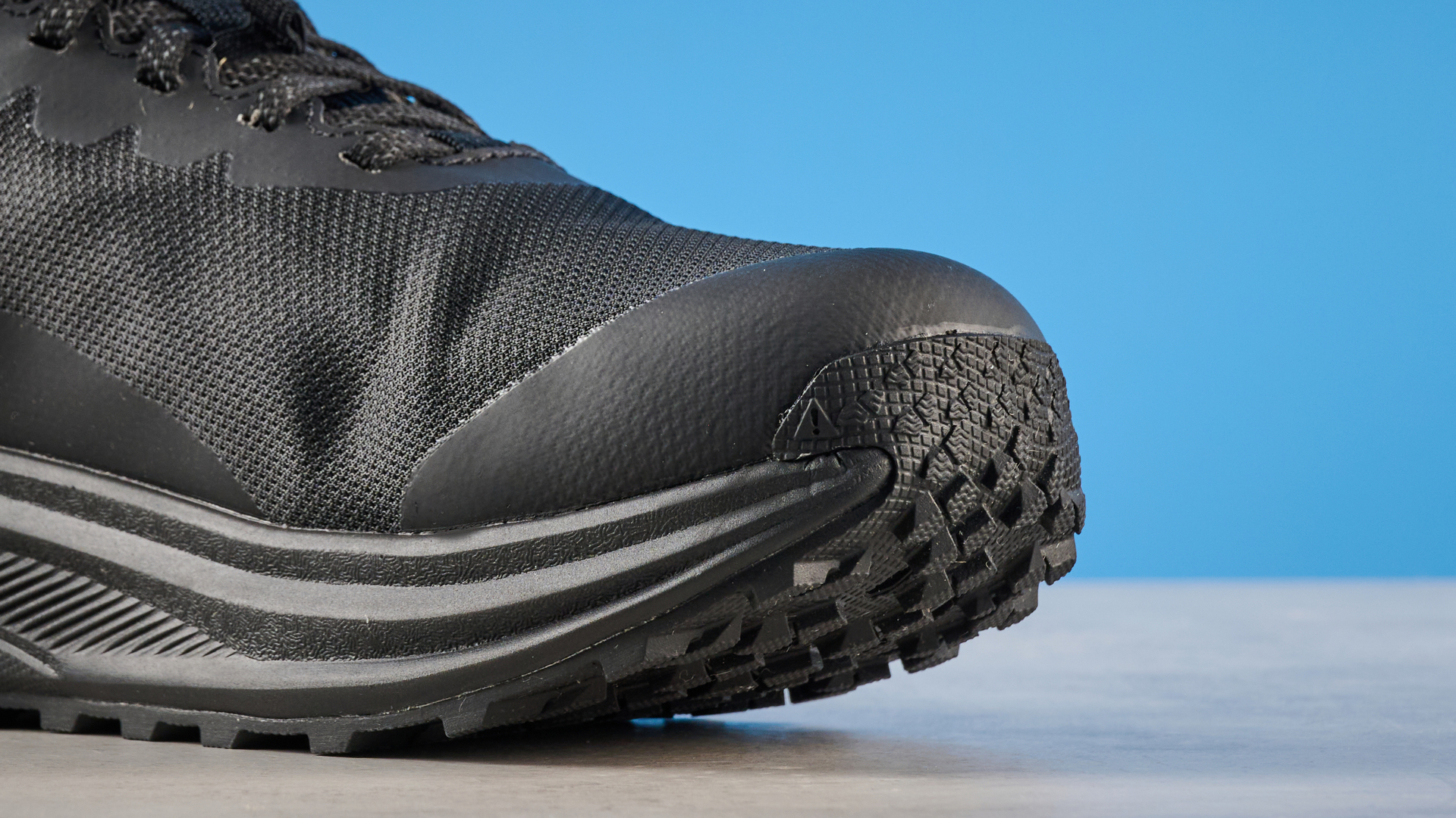 Keen Roam train running shoes in black photographed in front of a blue background