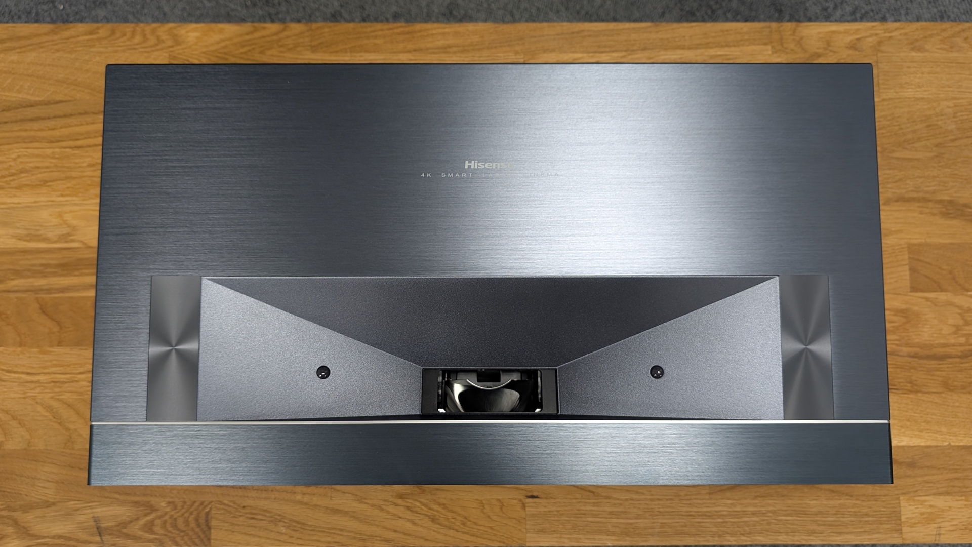 Hisense PX3 ultra short throw projector on wooden surface top down view