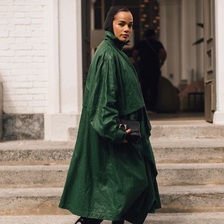 woman wearing green jacket with steps behind her