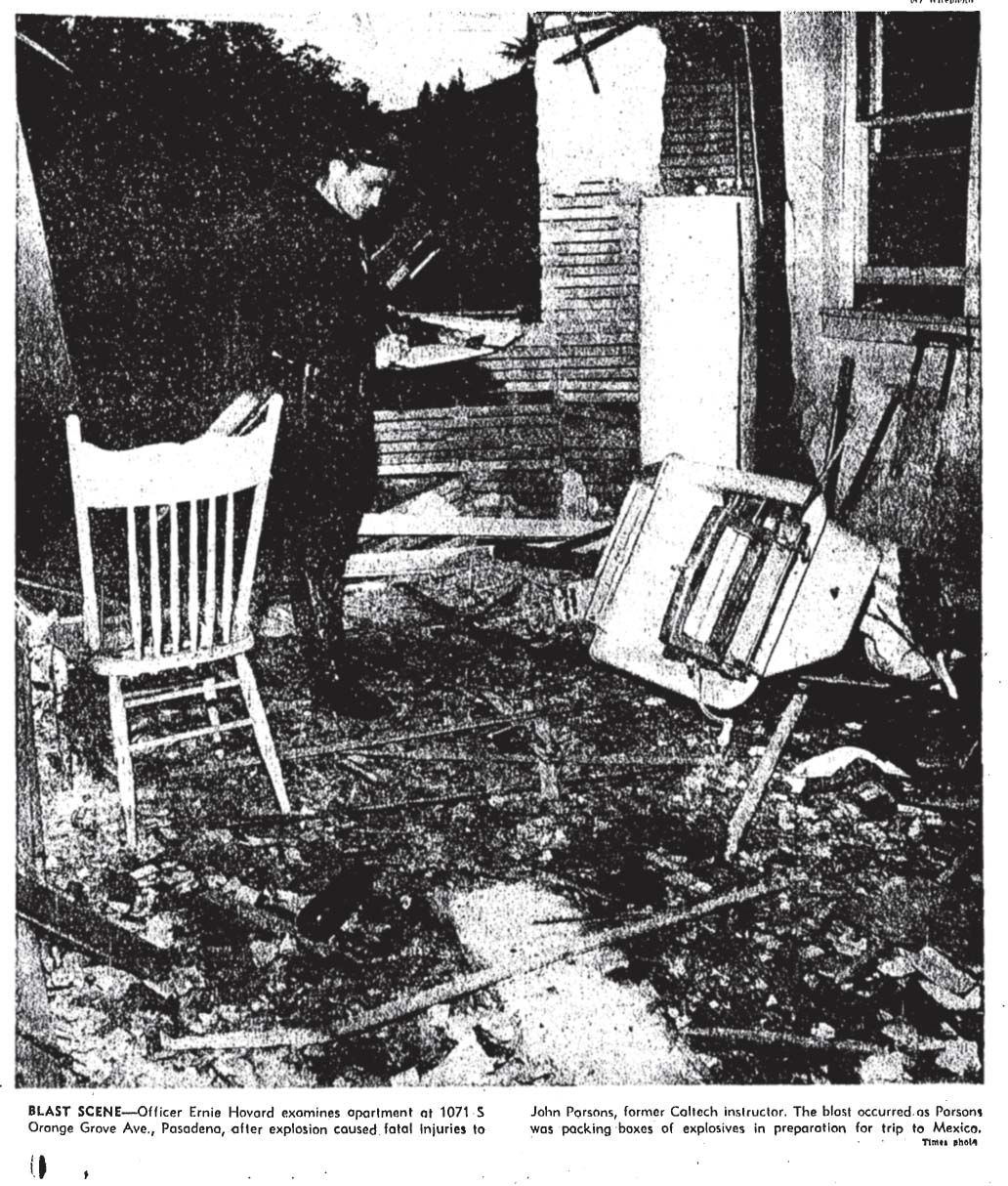 a police officer stands in a burned-out room with overturned furniture and destroyed walls
