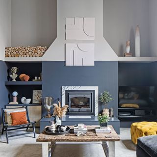 navy blue and white colored fire place with wall-mounted shelves decorated with accessories, and a wooden coffee table next to a chair and multiple sofas