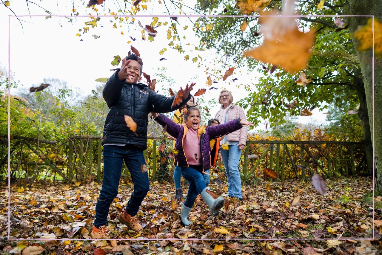 Children wearing winter jackets playing in leaves