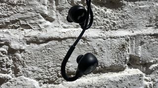 NuraLoop workout earbuds hanging on a wall