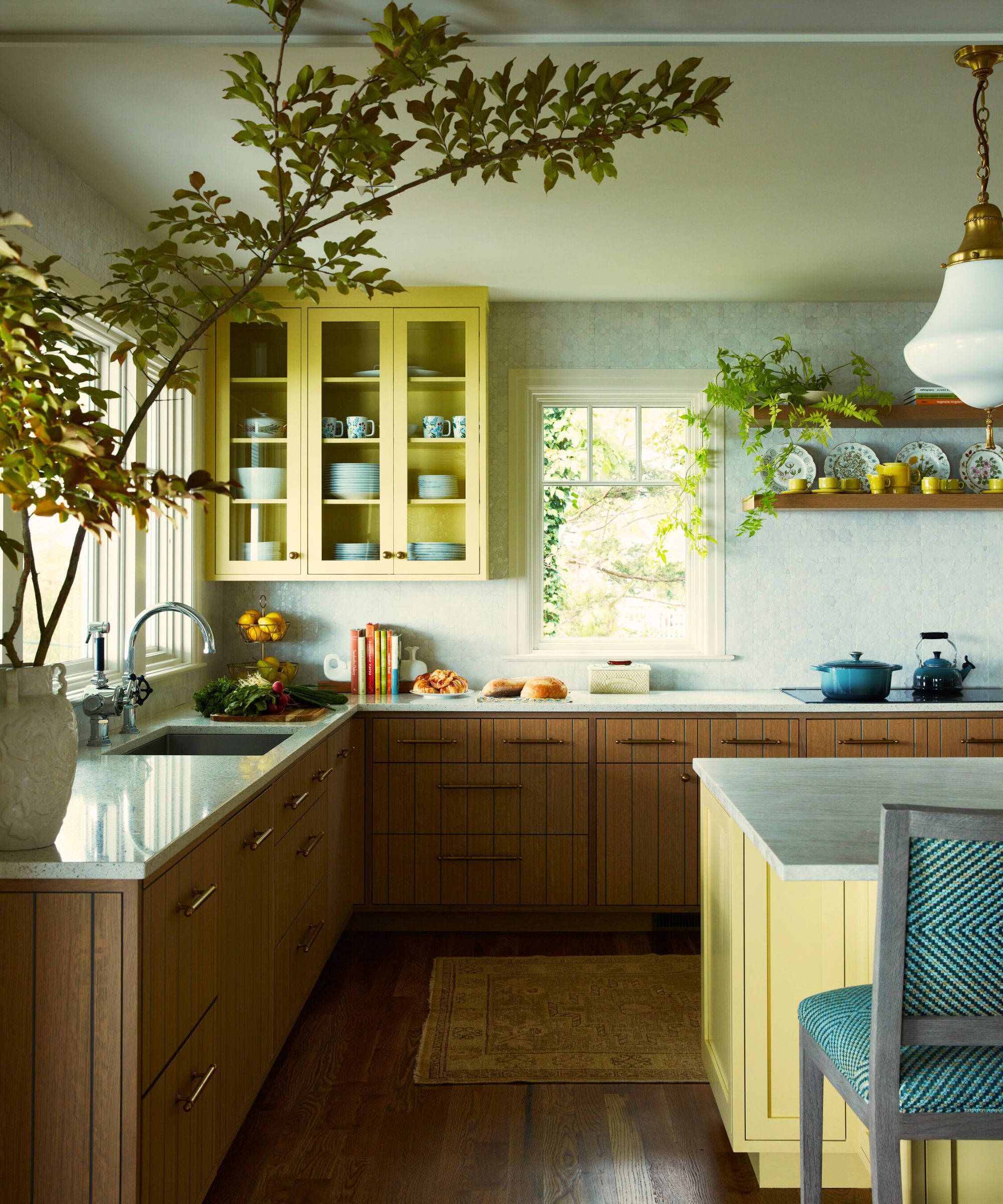 wooden kitchen with yellow kitchen island and yellow upper cabinets with hints of blue