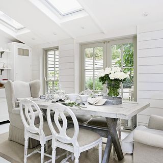 dining area with white wall and wooden dining table