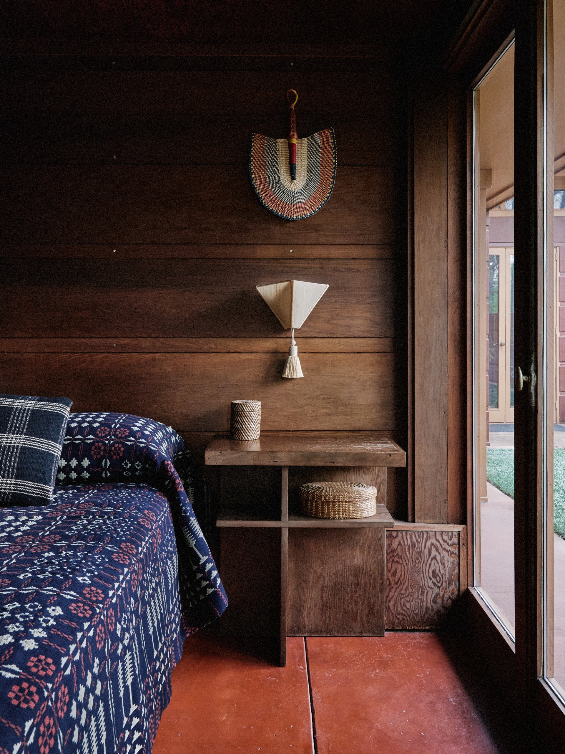 a frank lloyd wright house's bedroom with a white wall sconce with a tassel