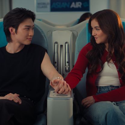 kitty covery song and min jo hold hands on a flight together before it takes off in a still from the xo kitty season 3 finale