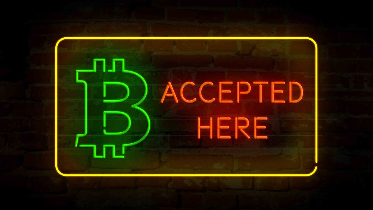 A neon &amp;quot;Bitcoin accepted here&amp;quot; sign.