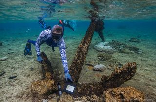 Maritime archaeologist Pete Illidge examines one of three large Admiralty-pattern anchors in the water at Kenn Reefs.