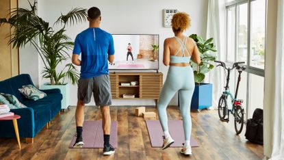 Couple complete a HIIT workout in their living room