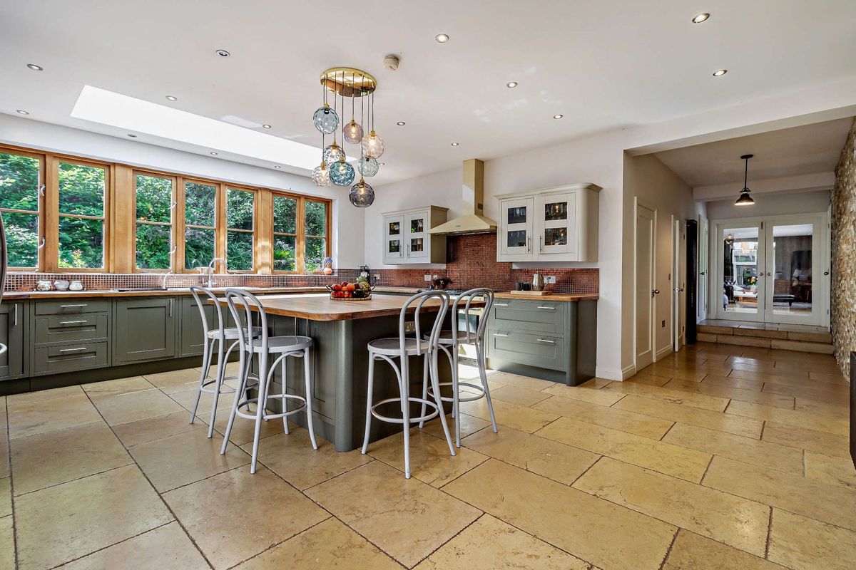 The kitchen has a small kitchen island and marble flooring