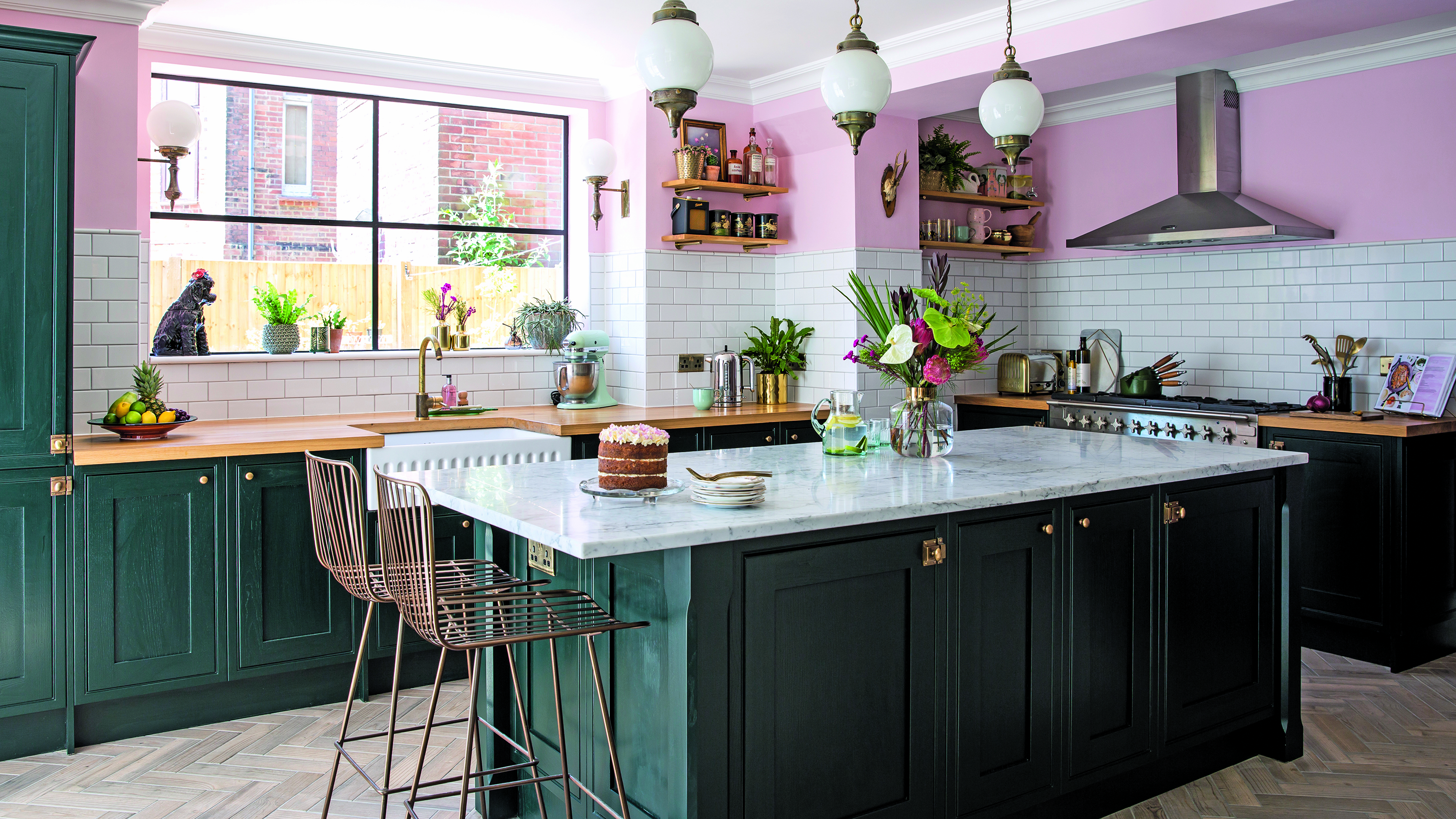 Green shaker kitchen with white tiles and pink walls