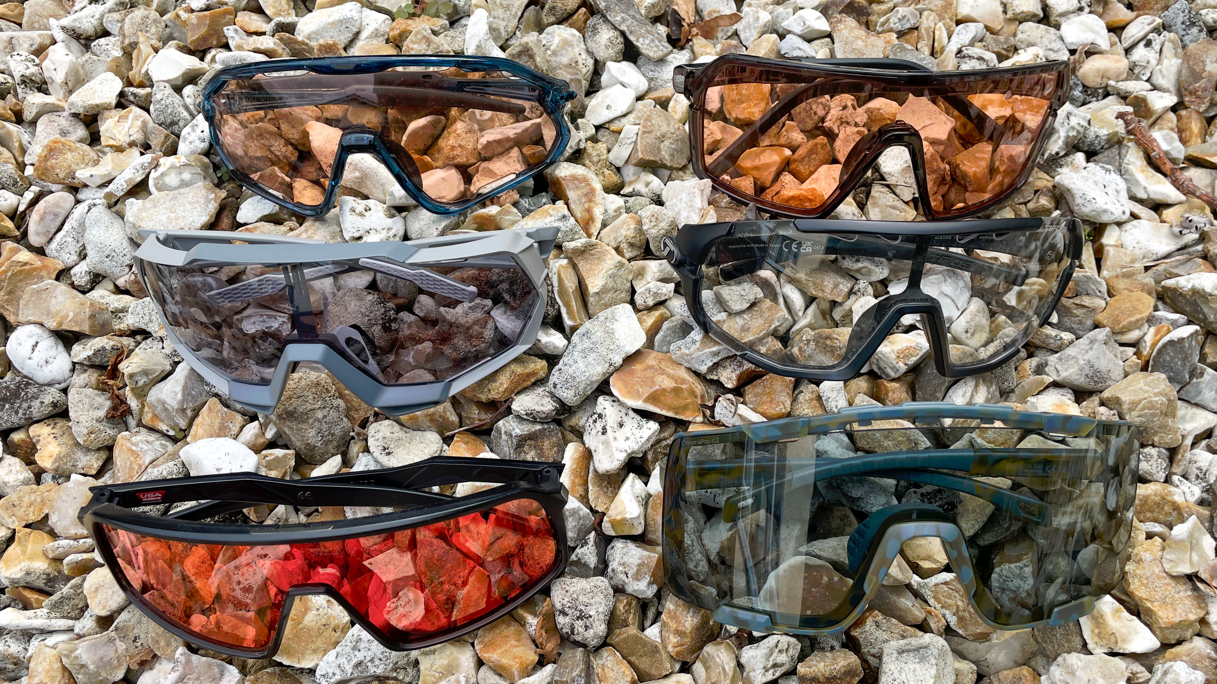 Six pairs of the best mountain bike sunglasses on a background of stone chippings