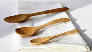 A trio of wooden spoons on a folded white chef's apron