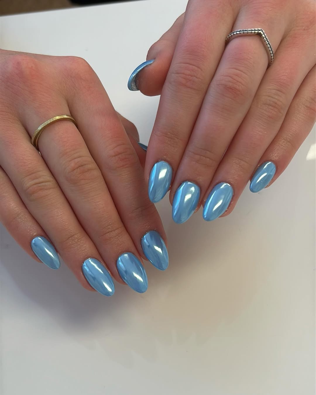 a person wearing light blue chrome nails