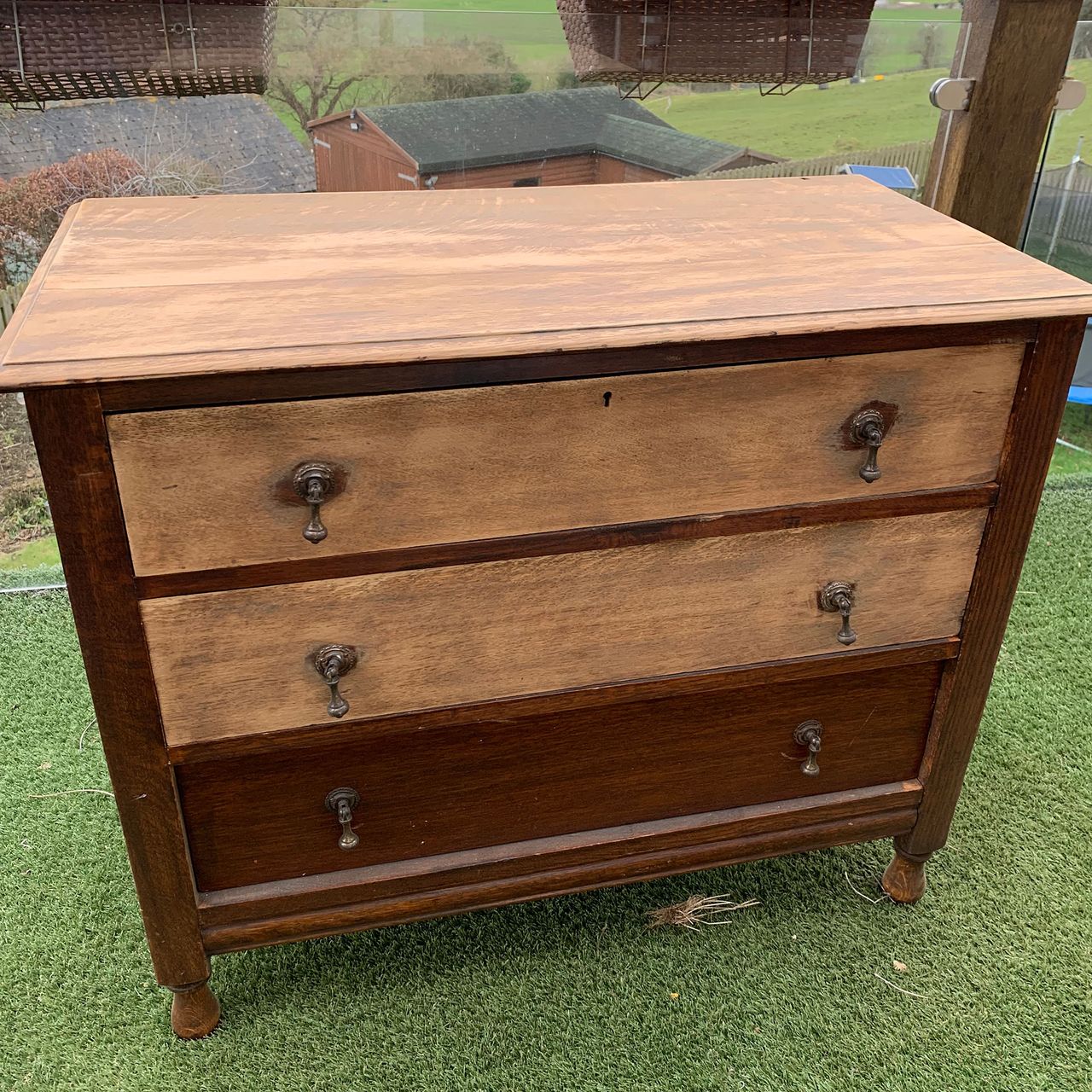 Wooden chest of drawers on grass in garden