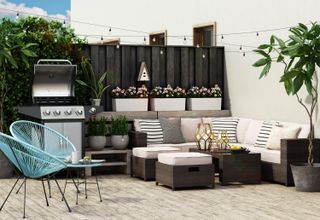 Trio of white window boxes in outdoor living area including BBQ grill, a neutral colored corner couch and bright turquoise garden chairs