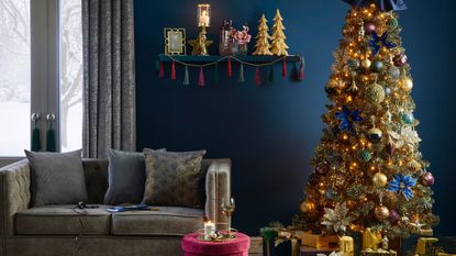 7ft Midnight Luxe Dream Christmas Tree by Wilko with green tinsel fir in blue living room with silver-grey sofa and shelving