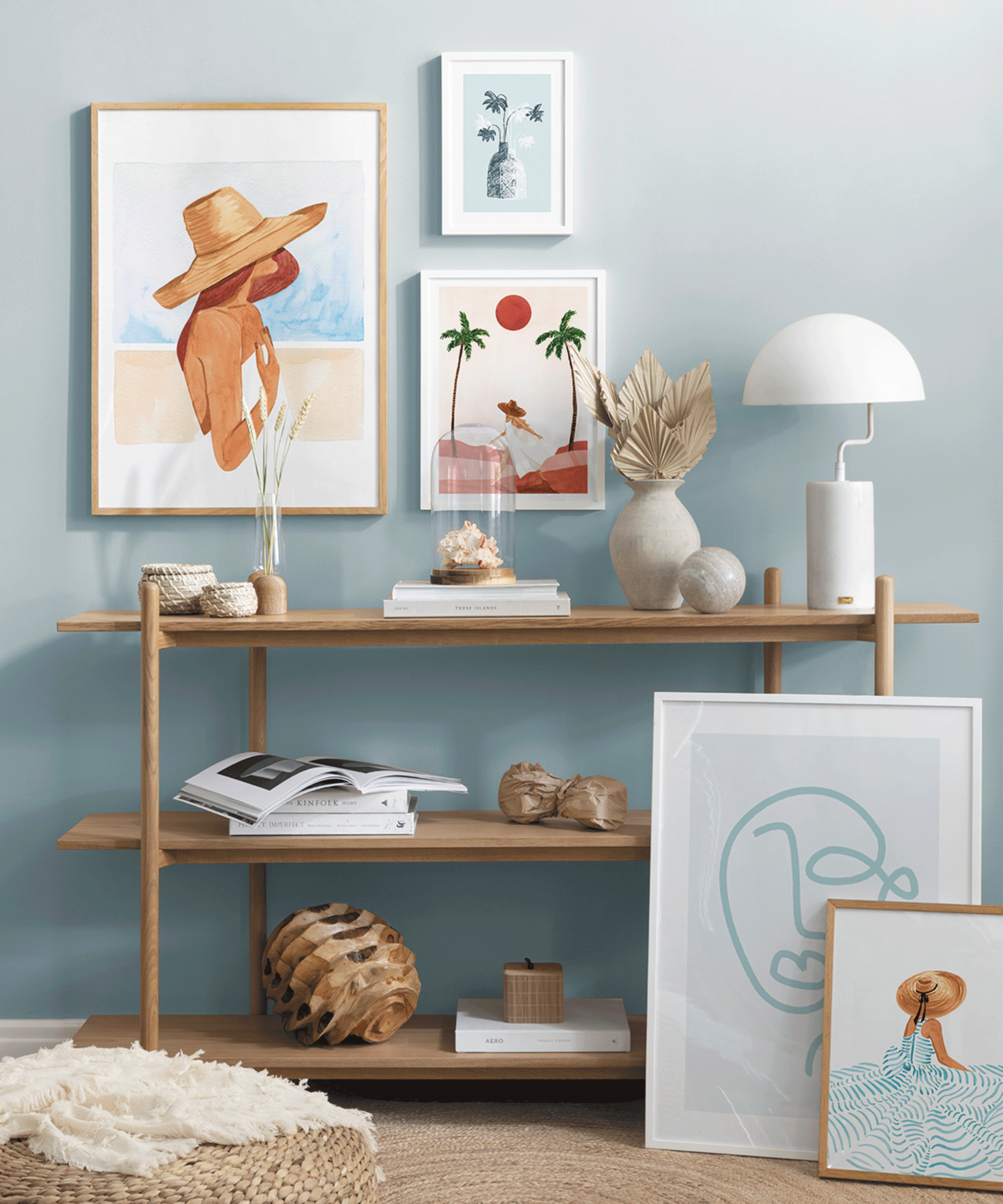 Beach inspired framed poster printed wall art with wooden shelving, white vase and hardback books