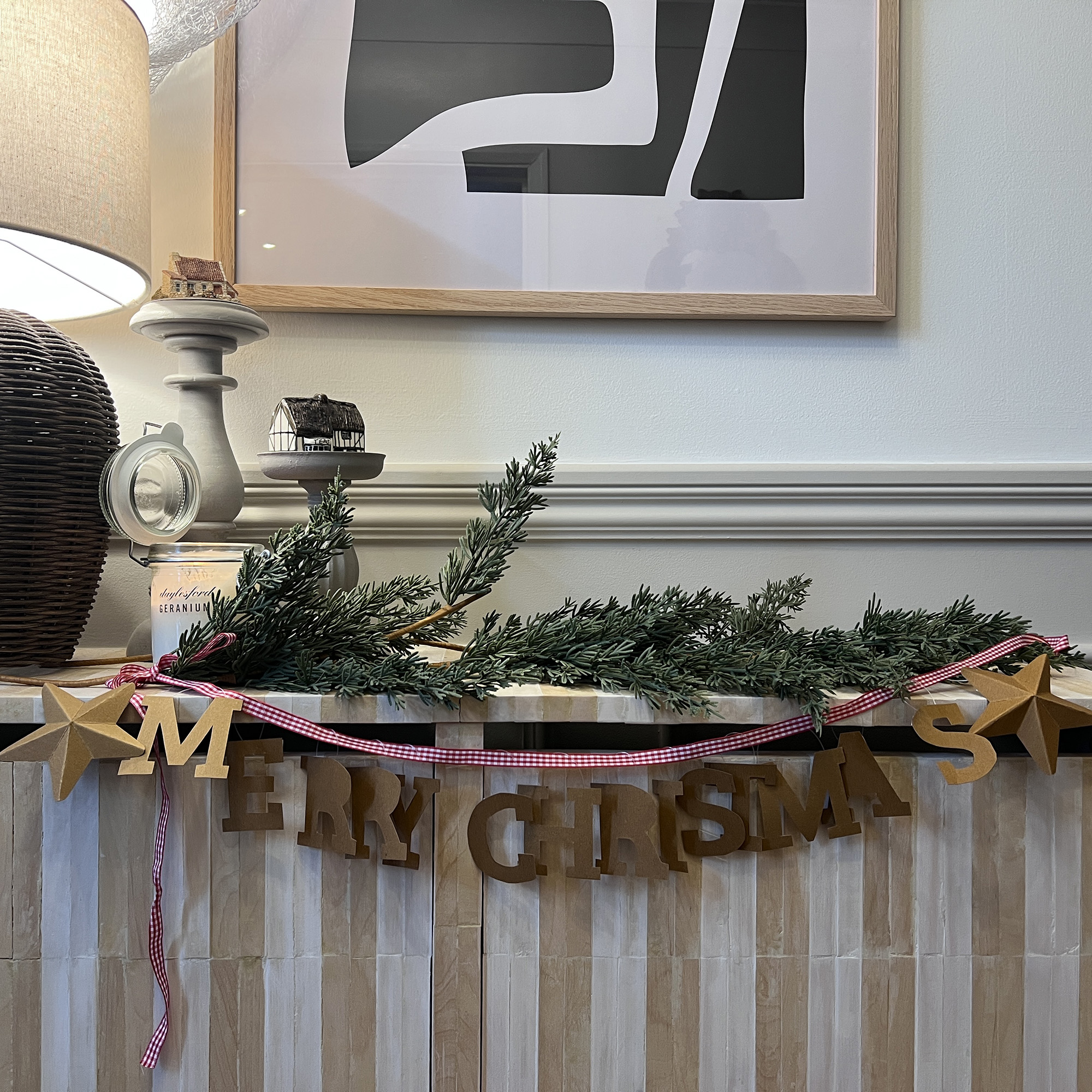 merry christmas garland on a stripy console