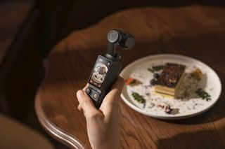 DJI Pocket 3 in the hand shooting food video content with screen in portrait format